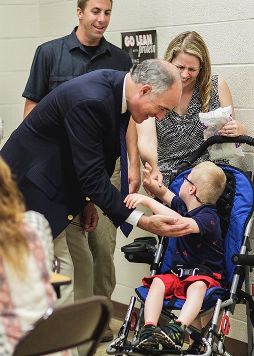 Senator speaking with a child with disabilities