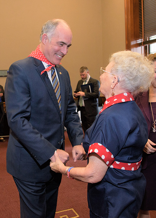 Senator with a Rosie the Riveter senior citizen